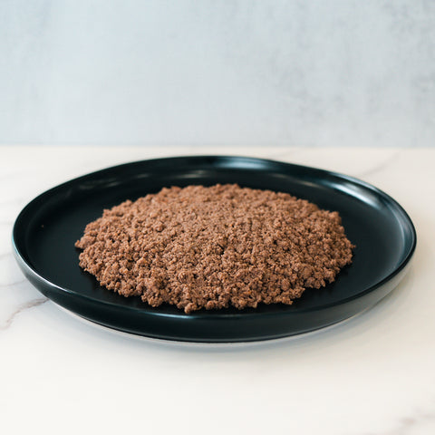 A mound of cooked, crumbled Competition Approved 90/10 Lean Ground Beef 1lb sits on a black plate against a neutral background—perfect for high protein meal prep.