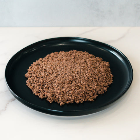 Enjoy a mound of Competition Approved 90/10 Lean Ground Beef 1lb, cooked and served on a round black plate atop white marble—ideal for high protein meal prep.
