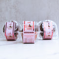 Three clear containers of Buffin Muffin Red Velvet are shown, each with a pink "Red Velvet" label featuring a bird illustration. The containers are set against a light, textured background.