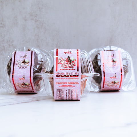 Three clear containers of Buffin Muffin Red Velvet are shown, each with a pink "Red Velvet" label featuring a bird illustration. The containers are set against a light, textured background.