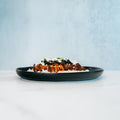 An Olympian Chicken Gyro Bowl - Exclusive featuring a bowl of rice topped with sliced chicken, crumbled cheese, and black olives.