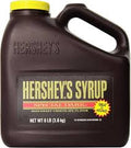 A large 8-pound jug of Dark Chocolate Syrup- For Shakes in a brown handled container with a yellow, white, and red label that reads “Semi-Sweet Chocolate Flavor.”.