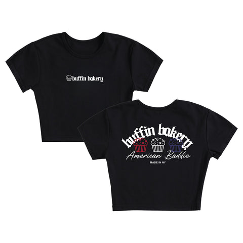 The American Baddie Baby Tee is a black crop top with the Baffin Bakery logo on the front and Baffin Bakery American Baddie MADE IN NY plus three colorful muffins on the back—a must-have NY streetwear cupcake shirt.