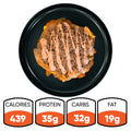 A black plate with a layered Animal Style West Coast Beef Bowl topped with sauce. This macro-friendly, high-protein meal prep option delivers 439 calories, 35g protein, 32g carbs, and 19g fat.