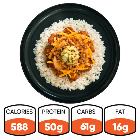 A serving of BBQ Meltdown—featuring white rice, BBQ chicken, cheddar cheese, and a relish topping on a black plate—creates the perfect high-protein meal prep with 588 calories, 50g protein, 61g carbs, and 16g fat.