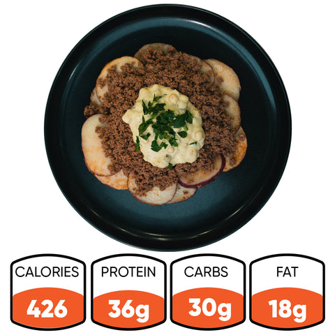 The Street Corn Beef Bowl features sliced potatoes, seasoned ground beef, creamy sauce, and herbs. It’s a macro-friendly meal prep with 426 calories, 36g protein, 30g carbs, and 18g fat per serving.