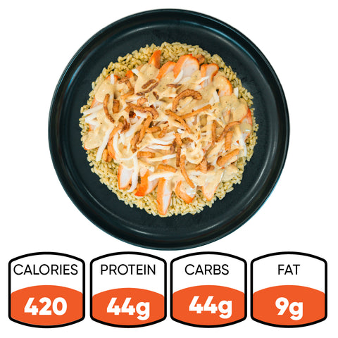 A black plate features the Brookfield Chicken Bowl—tender grilled chicken breast over rice, topped with shredded cheese and crispy fried onions—making it ideal for easy meal prep. Each bowl contains 420 calories, 44g protein, 44g carbohydrates, and 9g fat.