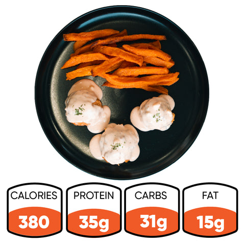 A serving of Buffalo Chicken Meatballs with sweet potato fries, arranged on a black plate, offers a tasty and healthy dinner or an easy meal prep option. Each serving provides 380 calories, 35g protein, 31g carbs, and 15g fat.