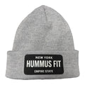 The Hummus Fit Empire State Patch Beanie is a light gray, cuffed hat with a black patch on the front featuring "NEW YORK HUMMUS FIT EMPIRE STATE" in white—perfect for gym-to-street style.