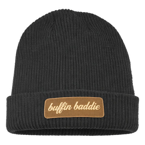 The Buffin Baddie Brown Patch Beanie is a black rib-knit hat with a folded brim and a brown patch embroidered with "buffin baddie" in white cursive—ideal for athleisure style or keeping warm during cold-weather workouts.