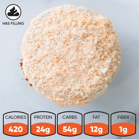 Top view of a crumb-covered Banana Cream Protein Dream CORE Team Edition muffin with filling icon and nutritional facts: 420 calories, 24g protein, 54g carbs, 12g fat, 1g fiber. A tasty high-protein dessert option.