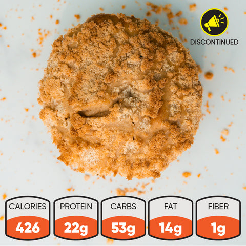 A crumb-topped Buffin Muffin in Crumb Cake discontinued sits on a white surface. Nutrition info: 426 calories, 22g protein, 53g carbs, 14g fat, 1g fiber. A yellow "DISCONTINUED" icon appears in the top right corner.