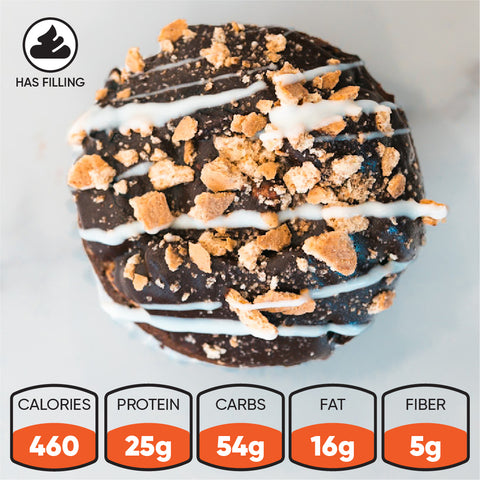 Introducing the Buffin Muffin: a chocolate-covered donut topped with white drizzle and crumbs, uniquely crafted with no added sugar. Nutrition highlights include 460 calories, 25g protein, 54g carbs, 16g fat, and 5g fiber per serving. Look for the filling icon in the top left corner.