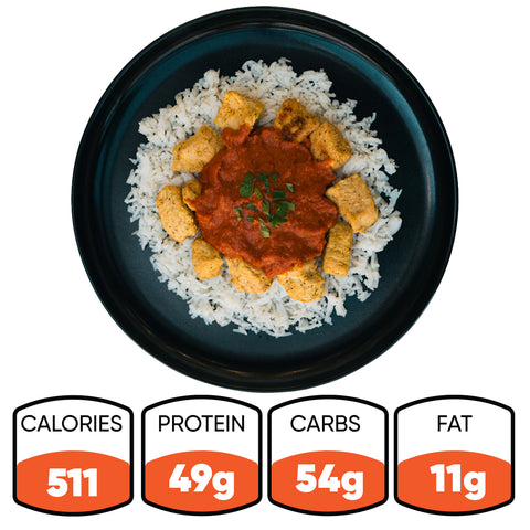 A black plate of Chicken Tikka Masala with white rice and herbs. This gluten free, high protein meal contains 511 calories, 49g protein, 54g carbs, and 11g fat—nutrition facts shown below the plate.