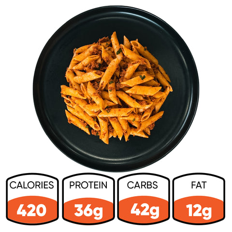 A black plate of The Clean Bulk Pasta Bowl—healthy pasta with sauce and herbs—is shown. Nutrition per bowl: 420 calories, 36g protein, 42g carbs, and 12g fat. A perfect high-protein meal prep for balanced eating.