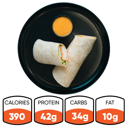 A black plate displays a sliced Crispy Baked Chicken Wrap and dipping sauce. Nutrition: 390 calories, 42g protein, 34g carbs, 10g fat—ideal for healthy meal prep or a high-protein lunch.