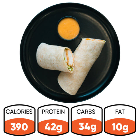 The Crispy Baked Chicken Wrap sits on a black plate with orange dipping sauce; nutrition info per serving: 390 calories, 42g protein, 34g carbs, and 10g fat—an ideal high-protein lunch for healthy meal prep.