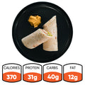 The Crispy Vegan Wrap is served halved on a black plate with dip. Each wrap has 370 calories, 31g protein and fiber, 40g carbs, and 12g fat—making it a perfect choice for a healthy lunch.