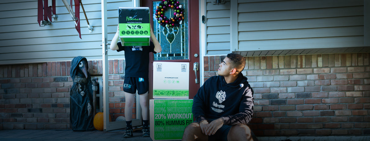 Hummus Fit meal delivery boxes on a front porch