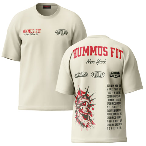 The New York Heritage Oversized Tee — Cream features HUMMUS FIT New York text, logos, and a Statue of Liberty graphic on premium cotton, highlighting sacrifice, growth, and community—authentic New York streetwear style.