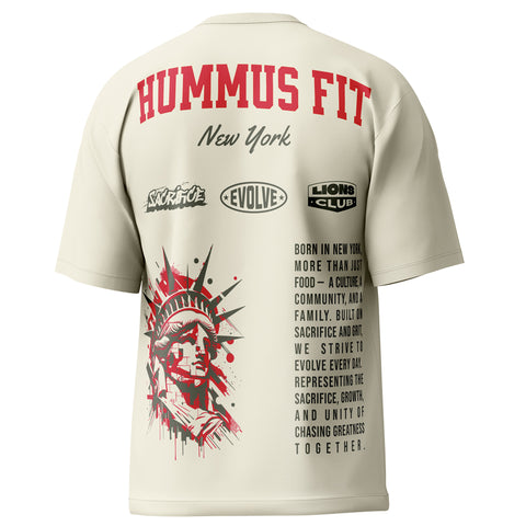 The New York Heritage Oversized Tee — Cream features red “HUMMUS FIT New York” text, a Statue of Liberty graphic, and motivational logos—“SACRIFICE”, “EVOLVE”, “LIONS CLUB”—for a classic New York streetwear look.