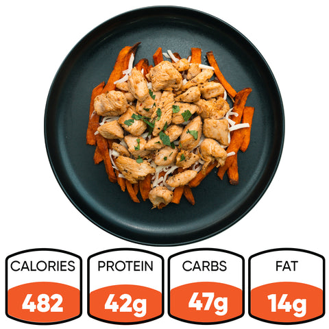 Lemon Pepper Chicken With Sweet Fries is served on a black plate, topped with herbs. Nutrition: 482 calories, 42g protein, 47g carbs, and 14g fat—making it a delicious High-Protein Meal.