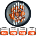 A black plate with buffalo-style chicken pieces drizzled with white sauce. Below, nutrition facts show: 456 calories, 30g protein, 48g carbs, and 16g fat.