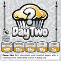 Buffin Muffin Mystery Flavor, Day 2: Illustration shows a cupcake with a question mark. Contains tree nuts hazelnut. Nutrition: 459 calories, 25g protein, 56g carbs, 15g fat, 2g fiber. Flavor hint: chocolate and hazelnut.