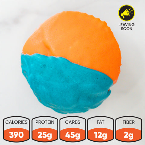 A Buffin Muffin with orange and blue icing rests on a white surface. With 390 calories, 25g protein, 45g carbs, 12g fat 2g fiber, it’s ideal pre- or post-workout. A "Leaving soon" icon appears in the top right corner.