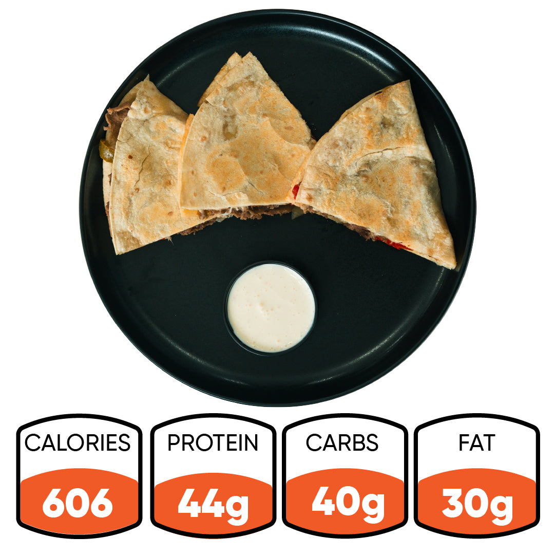 Three quesadilla slices served on a black plate with a cup of dipping sauce—our Philly Cheesesteak Quesadilla is your go-to macro-friendly meal for any occasion. Packed with 44g of protein, 40g of carbs, and 30g of fat at just 606 calories per serving. Perfect for high-protein meal prep and guilt-free satisfaction.
