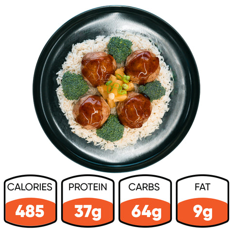 A black plate with rice, broccoli, and four Pineapple Teriyaki Meatballs topped with green onions. Nutrition: 485 calories, 37g protein, 64g carbs, 9g fat—Pineapple Teriyaki Meatballs are perfect for high-protein meal prep.