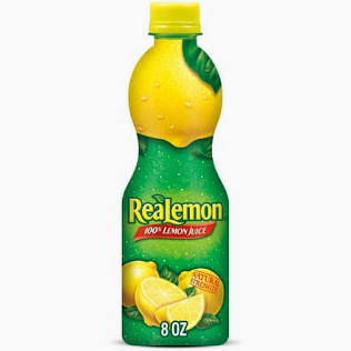 A green and yellow 8 oz bottle of Lemon Juice- For shakes, with a yellow cap and label showing lemons and leaves.