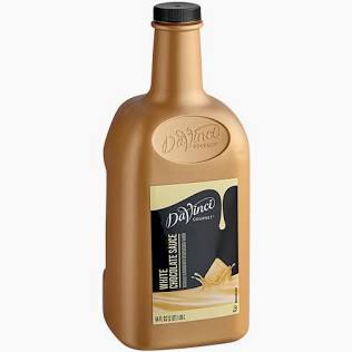 A gold plastic bottle of DaVinci Gourmet White Chocolate Sauce-For Shakes with a black cap and a label featuring a white chocolate splash.