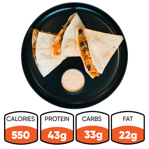 Three Southwest Chicken Quesadilla wedges are arranged on a black plate and served with a small cup of chipotle sauce in the center. Each serving contains 550 calories, 43g protein, 33g carbs, and 22g fat—a tasty and nutritious Southwest Chicken Quesadilla meal prep choice.