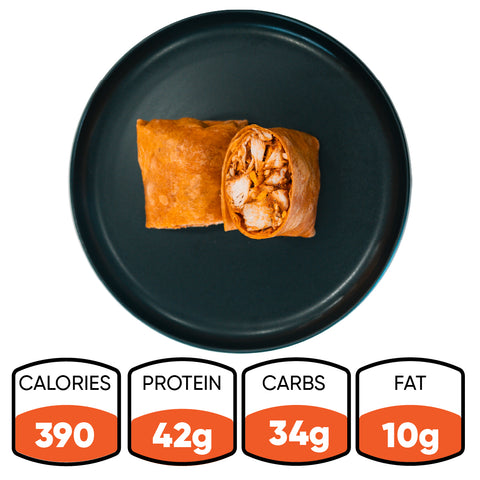 A Spicy Buffalo Wrap, sliced in half and served on a black plate. Below, the nutrition info highlights: 390 calories, 42g protein, 34g carbs, and 10g fat—ideal for healthy wraps or meal prep.
