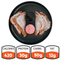 A black plate displays four halves of Strawberry Protein French Toast, crafted from thick Texas toast and sprinkled with powdered sugar, encircling two dipping sauces in the center. This low sugar breakfast option delivers 420 calories, 30g protein, 50g carbs, and 12g fat.