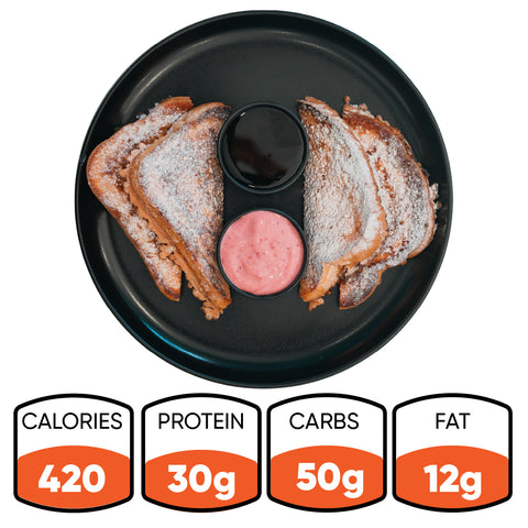 A black plate displays four halves of Strawberry Protein French Toast, crafted from thick Texas toast and sprinkled with powdered sugar, encircling two dipping sauces in the center. This low sugar breakfast option delivers 420 calories, 30g protein, 50g carbs, and 12g fat.