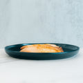 A teal plate with two pieces of Baked Herbed Tilapia 1lb Competition Approved sits on a white surface, perfect for meal prep or weight loss plans.