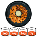 A black plate holds the Zeus Bowl V2: seasoned chicken kebab chunks, diced roasted potatoes, and a cup of dipping sauce. Nutrition stats below show 400 calories, 49g protein, 34g carbs, and 7g fat.