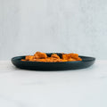 A serving of seasoned, cubed tofu or paneer—resembling chicken kebab—is presented on the Zeus Bowl V2, placed on a light surface with a minimalist background, viewed from the side.