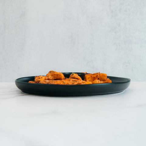 A serving of seasoned, cubed tofu or paneer—resembling chicken kebab—is presented on the Zeus Bowl V2, placed on a light surface with a minimalist background, viewed from the side.